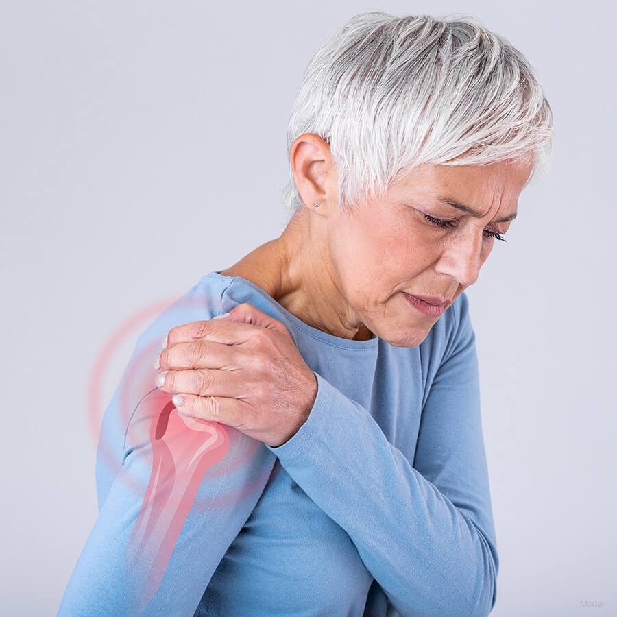 Woman holding her shoulder in pain